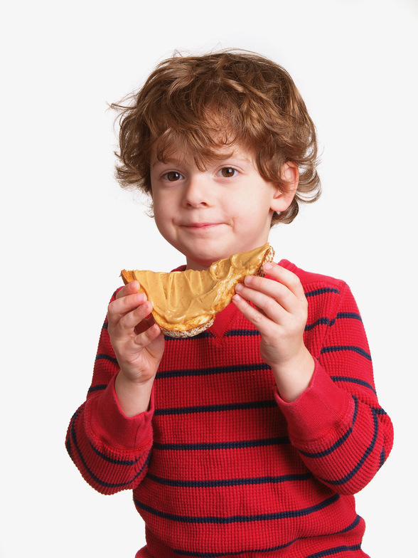 A boy eating bread and peanut butter